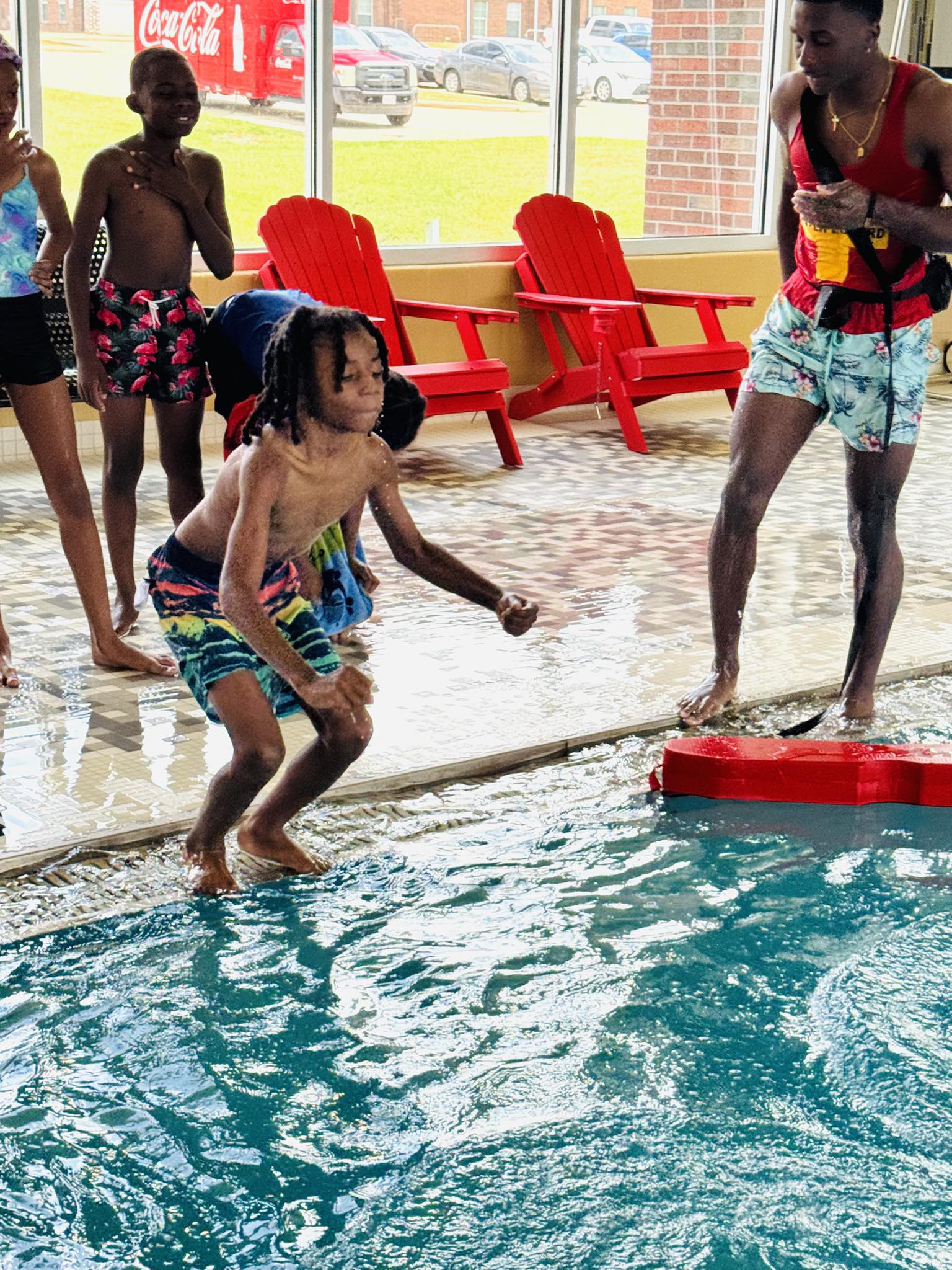 A boy jumping into a swimming pool.